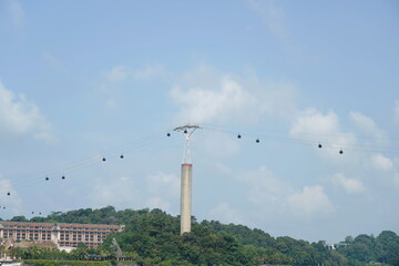 Obraz premium The Singapore Cable Car is a scenic aerial ropeway offering breathtaking views of Singapore’s skyline, harbor, and lush greenery. It connects Mount Faber, HarbourFront, and Sentosa Island, providing a