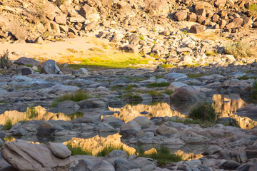 Golden Reflection of the cliffs of the Fish River Canyon into the river in the late afternoon.