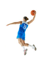 Young athletic woman wearing sports uniform doing perfect slam dunk in motion against white studio...