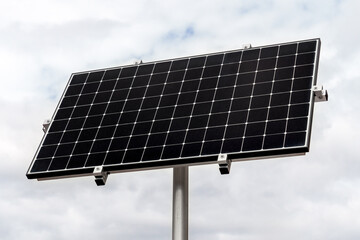 Single solar panel mounted on a pole as a renewable energy object against the sky
