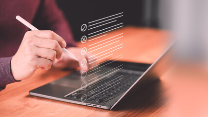 Male employee using a computer laptop making online checklist survey. Business performance...