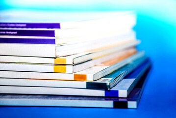 stack of magazines on blue background isolated