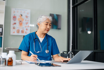 Beautiful physician doctor sit on table in office hospital. Attractive therapist female practitioner pharmacist smile and use tablet