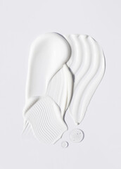 samples of cosmetic care products smear of cream and gel texture on a light background