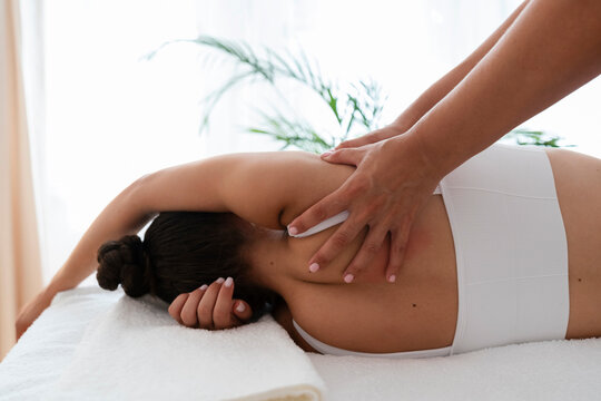 Hands of physical therapist treating patient for chiropractic back adjustment in hospital