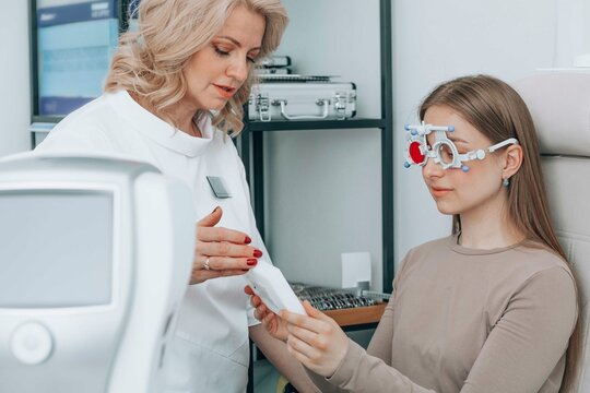 Doctor examining patient's vision with eye chart at clinic