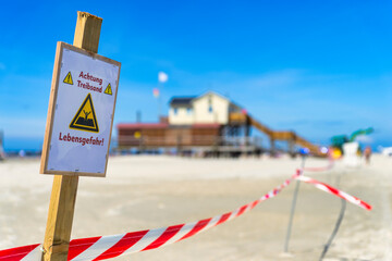 Germany, Schleswig-Holstein, St. Peter-Ording, Warning sign on sandy beach