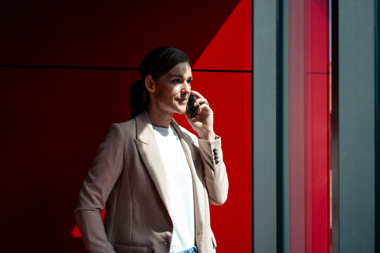 Businesswoman wearing blazer and talking on smart phone at office