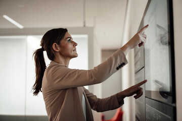 Businesswoman using digital screen and working at office