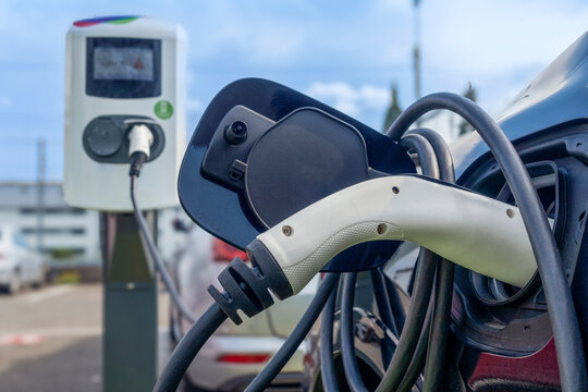 Electric car charging at station on sunny day