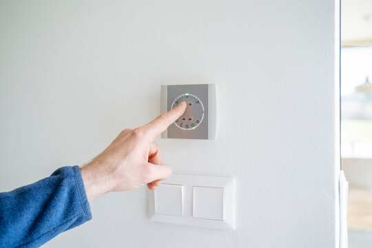 Hand of man pressing temperature control switch