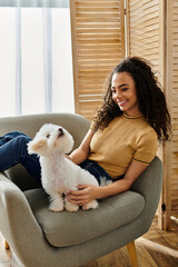A young woman sitting on a chair with her white Bichon Frise dog.