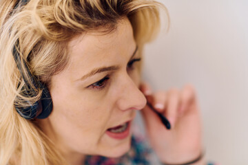 Obraz premium Friendly Call Center Agent Answering Incoming Calls with Headset Providing Remote Customer Service.