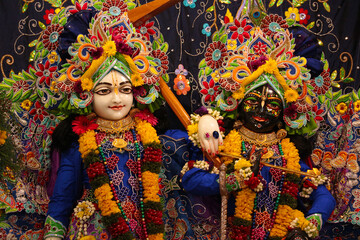 Altar of Krishna and Balarama in the temple decorated with flowers and garlands.