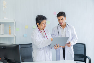 Two collaboration doctors team from professional hospital discussing patient information on laptop and tablet. medical office specialist private conference setting in pediatric care with data analysis
