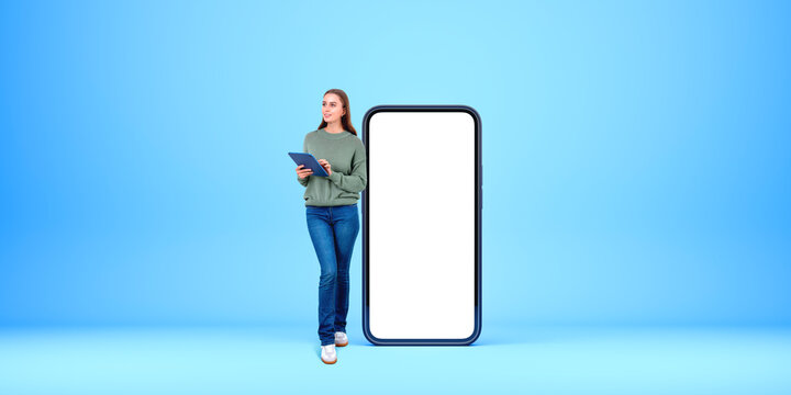 Smiling woman with tablet in hands, mock up blank smartphone display