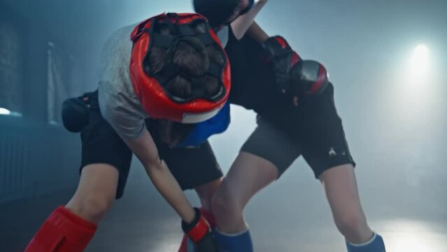 Boys training martial arts. Children training together in foggy room. Sparring. Focused kids sparring and practice fight technique. 4K, UHD