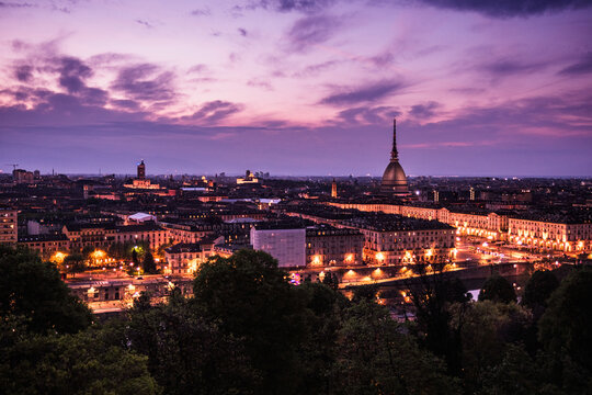 Parple panoramic dusk view of Turin skyline and Mole Antonelliana from Church of Santa Maria del Monte dei Cappuccini