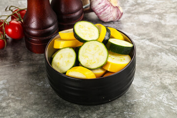 Sliced raw young green and yellow zucchini