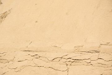 A close-up image of tan sand with visible cracks