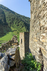 Stone walls and towers of medieval village Shatili. Mountains on background.