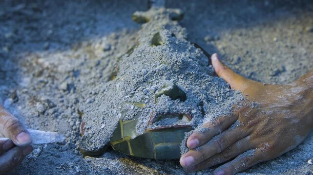 Maya jade mask being discovered by an archaeologyst