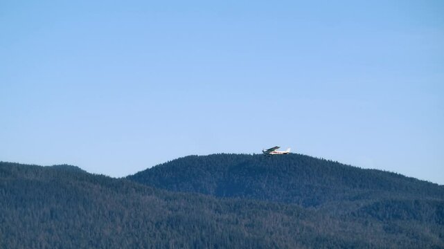 Small Propeller Plane Flying over Forested Hills on a Sunny Day TRACK