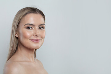 Fototapeta premium Beauty Woman Face Studio Portrait. Beautiful Spa Model with Perfect Fresh Clean Skin. Blonde Female Looking at camera and smiling. Youth and Skin Care Concept