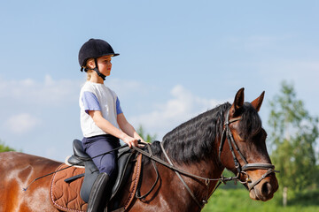 Horse riding school. Little children girls at group training equestrian lessons at outdoors ranch...