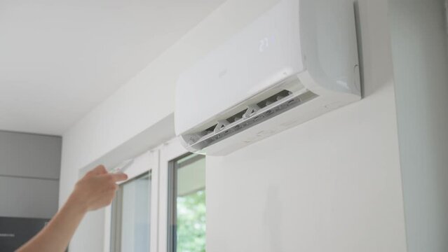 Air conditioner mounted on white wall in modern apartment. Cooling system for comfortable temperature in living room