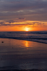 Breathtaking sunset at peaceful beach with calm water, reflections, lovely horizon under colorful sky