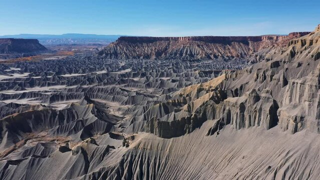 Unique erosion formations of steel blue smooth sharp rocks in mudstone canyon in desert valley western Usa. Factory Butte and moonscape. Aerial view drone flying side near slope. Land desertification