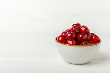 Cherries. Fresh ripe cherries with leaves on a textured wooden background. Fresh sweet organic cherry pile. Berries and fruits. Vegan. Healthy eating. Place for text. Copy space