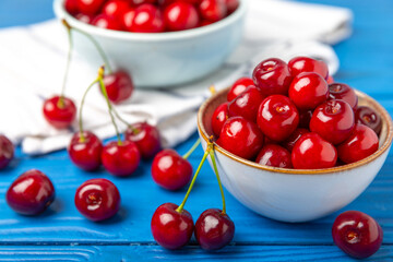 Cherries. Fresh ripe cherries with leaves on a textured wooden background. Fresh sweet organic cherry pile. Berries and fruits. Vegan. Healthy eating. Place for text. Copy space