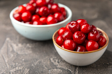 Cherries. Fresh ripe cherries with leaves on a textured wooden background. Fresh sweet organic cherry pile. Berries and fruits. Vegan. Healthy eating. Place for text. Copy space