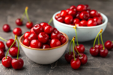 Cherries. Fresh ripe cherries with leaves on a textured wooden background. Fresh sweet organic cherry pile. Berries and fruits. Vegan. Healthy eating. Place for text. Copy space