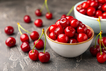 Cherries. Fresh ripe cherries with leaves on a textured wooden background. Fresh sweet organic cherry pile. Berries and fruits. Vegan. Healthy eating. Place for text. Copy space