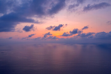 Beautiful sunset cloudy sky with sunlight from aerial top view, toning. Drone photo above clouds