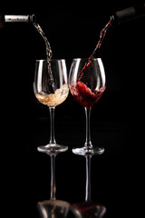 Glasses of red and white wine are poured. On a dark background.