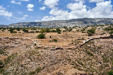 rocky valley slope with olive trees and white houses in the mountains on the island of Cyprus