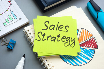 Sales strategy in notepad with charts and graphs.