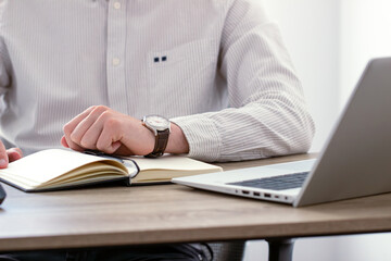 businessman looking at classic wristwatch, time management concept