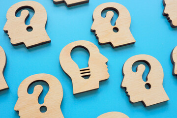 Creative thinking and problem solving. Heads with question marks and a light bulb.