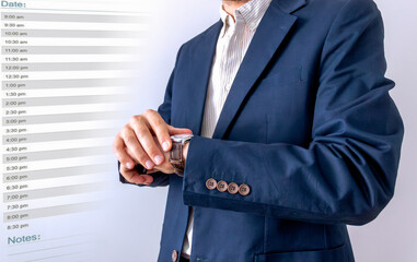businessman looking at classic wristwatch,diary page background, time management concept