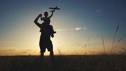 Silhouette of father and son bending his neck. Daughter parent beach concept. A father walks his...