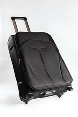Black suitcase on wheels stands against a vibrant background