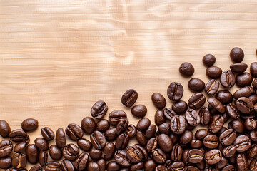 Roasted raw coffee beans on a wooden surface. Copy space. Top to down view. Beverage concept