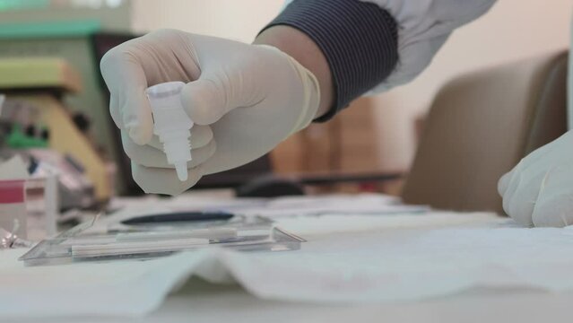 A gloved hand using a dropper on HIV rapid test kit, HIV testing, highlighting HIV testing campaign, VCT day