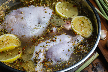 Soaking the chicken in a brine solution using lemon, herbs and aromatic