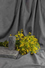 There is a podium on a gray draped background and a bouquet of yellow flowers
